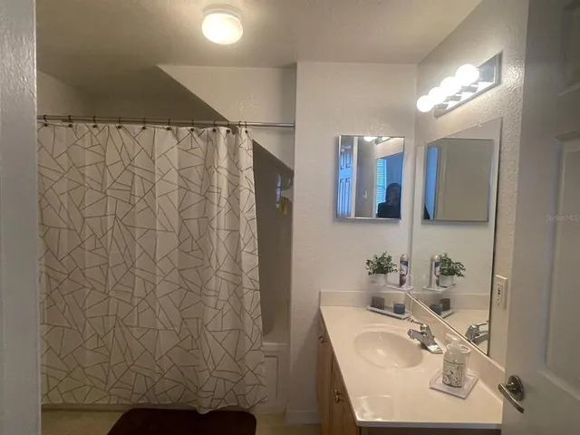 a bathroom with a sink a mirror and a shower