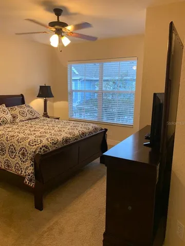 a bedroom with a bed and a flat tv screen on the dresser