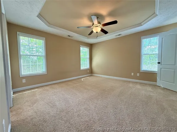 an empty room with windows and fan
