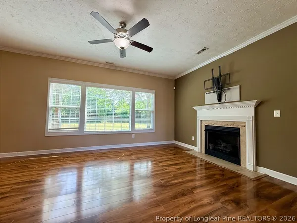 a view of empty room with wooden floor and fireplace