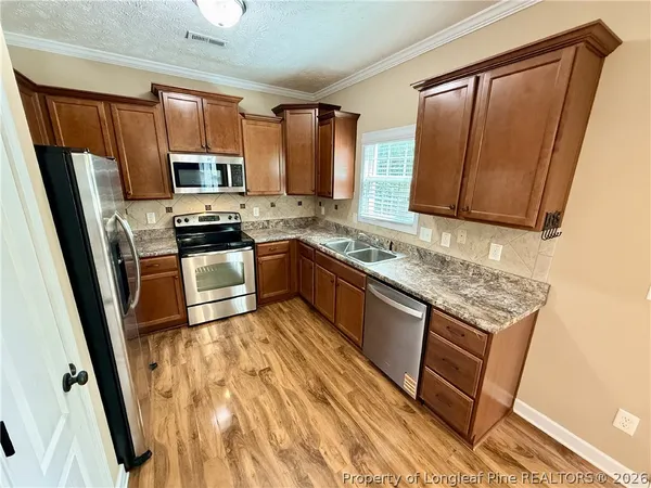a kitchen with stainless steel appliances granite countertop a stove a sink dishwasher a refrigerator and a microwave