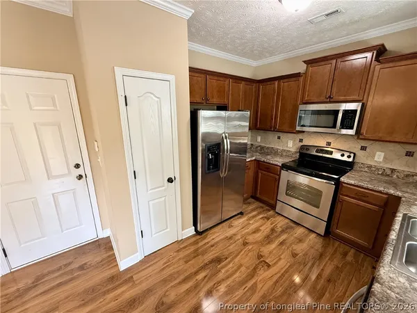 a kitchen with stainless steel appliances granite countertop a refrigerator stove and sink