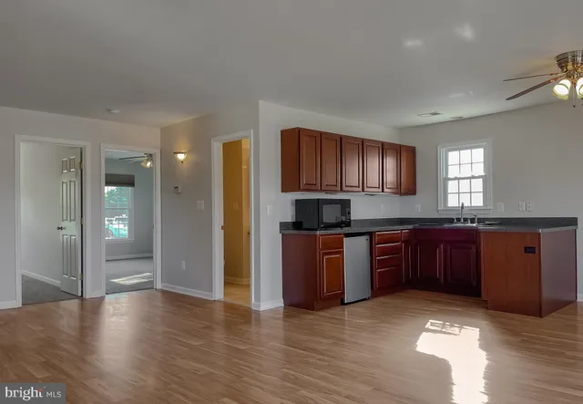 an empty room with a window and a ceiling fan