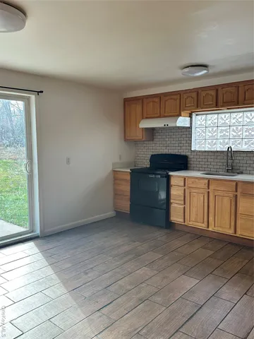 a kitchen with stainless steel appliances granite countertop a sink and a stove