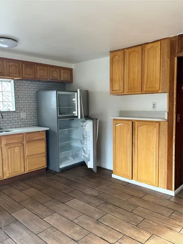 a kitchen with granite countertop wooden cabinets and a stove top oven