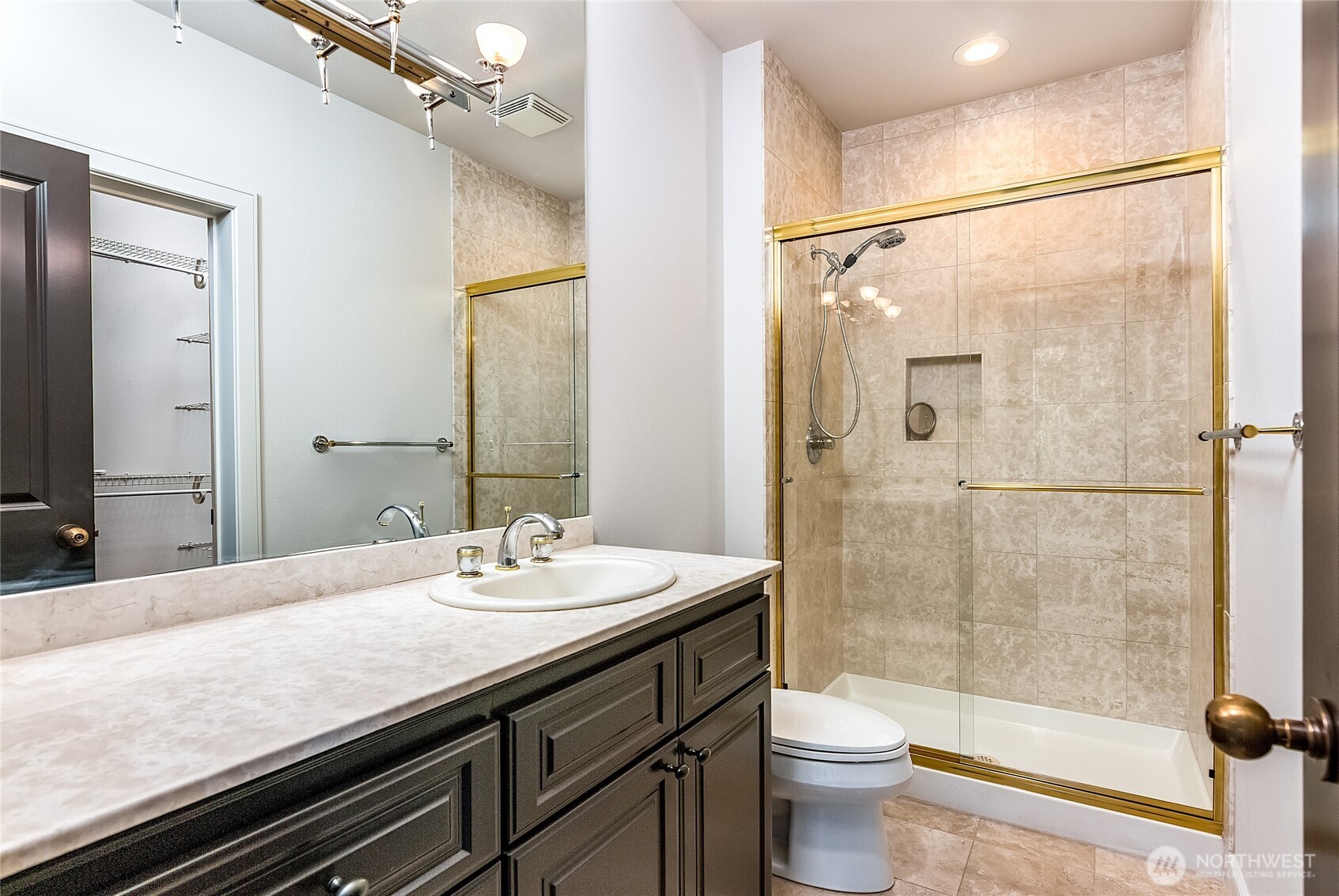 21 West Comstock Street, Unit 102 Seattle, WA 98119 - Photo 11 of 22 a bathroom with a granite countertop shower sink vanity mirror and toilet