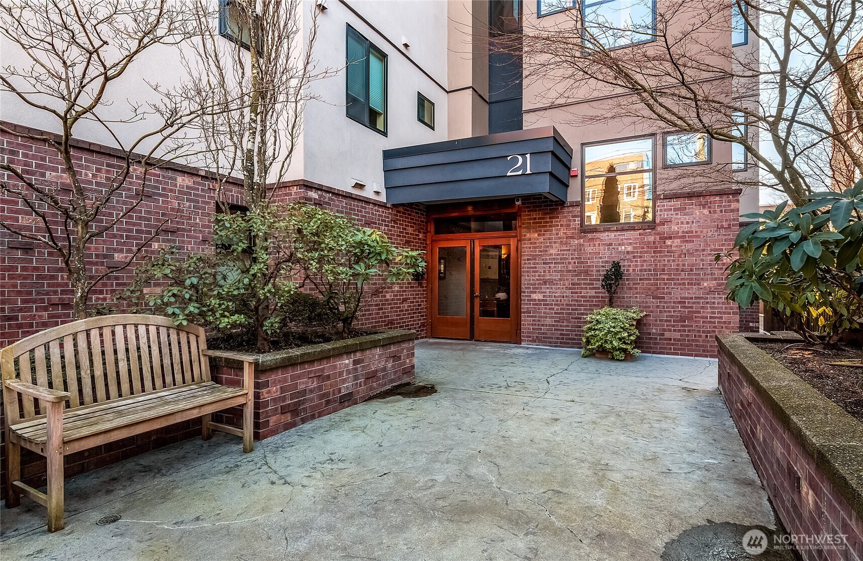 21 West Comstock Street, Unit 102 Seattle, WA 98119 - Photo 2 of 22 a view of a house with a wooden fence and trees