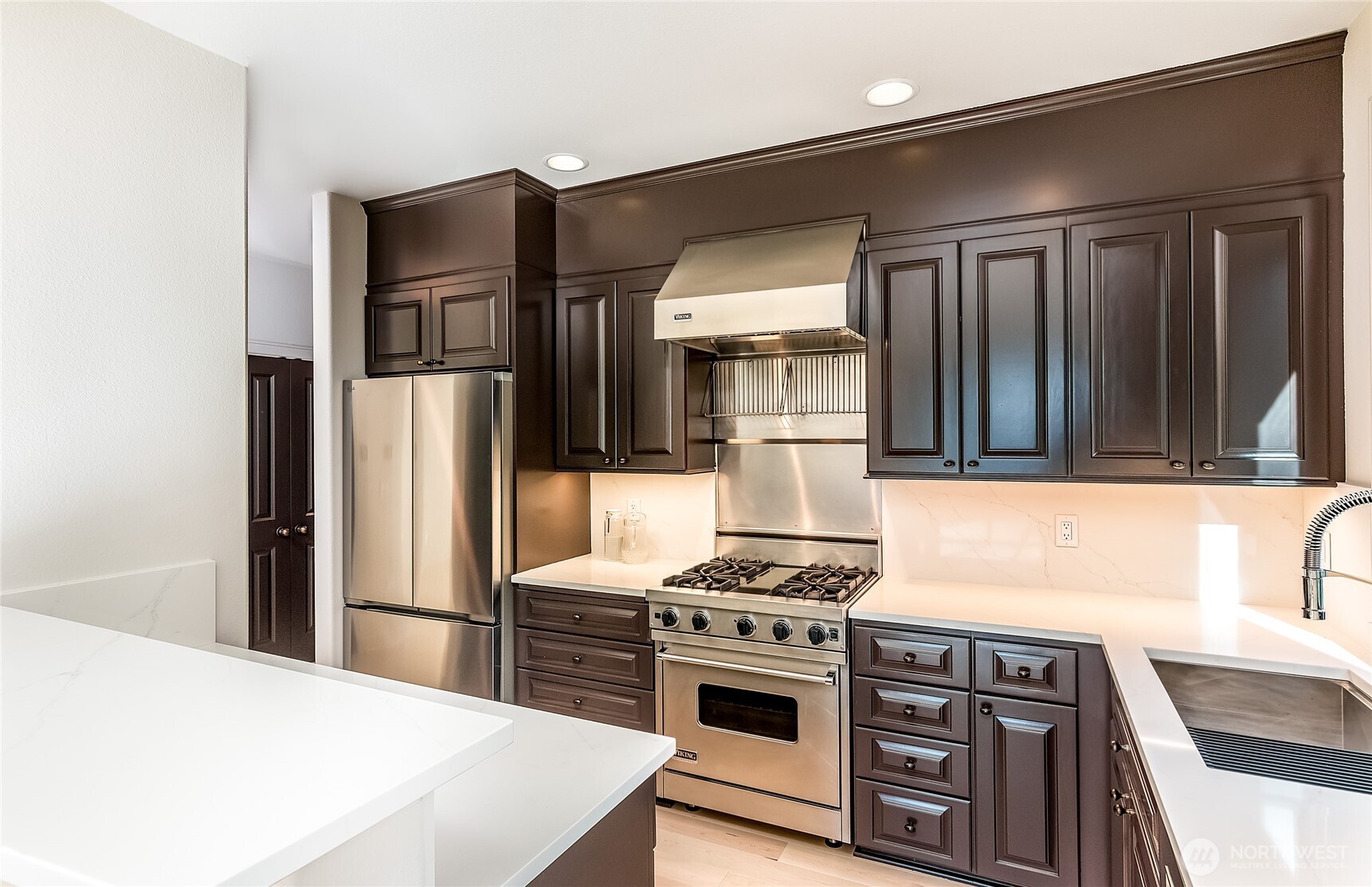21 West Comstock Street, Unit 102 Seattle, WA 98119 - Photo 3 of 22 a kitchen with stainless steel appliances a refrigerator a stove and a sink