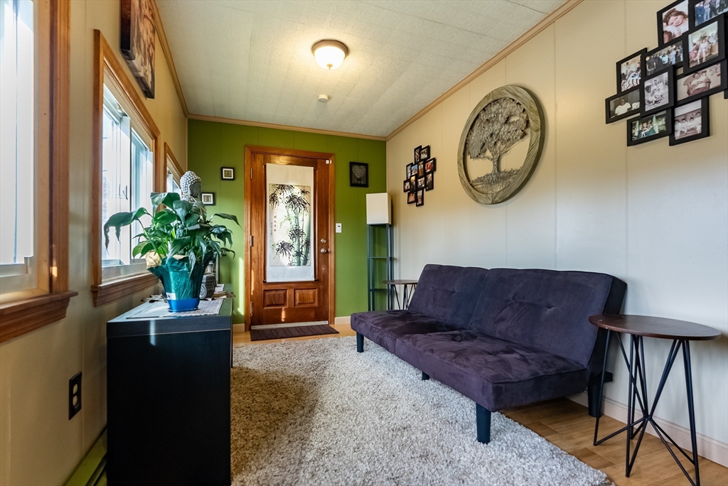 3853 North Main Street Fall River, MA 02720 - Photo 20 of 38 a living room with furniture a chandelier and a large mirror