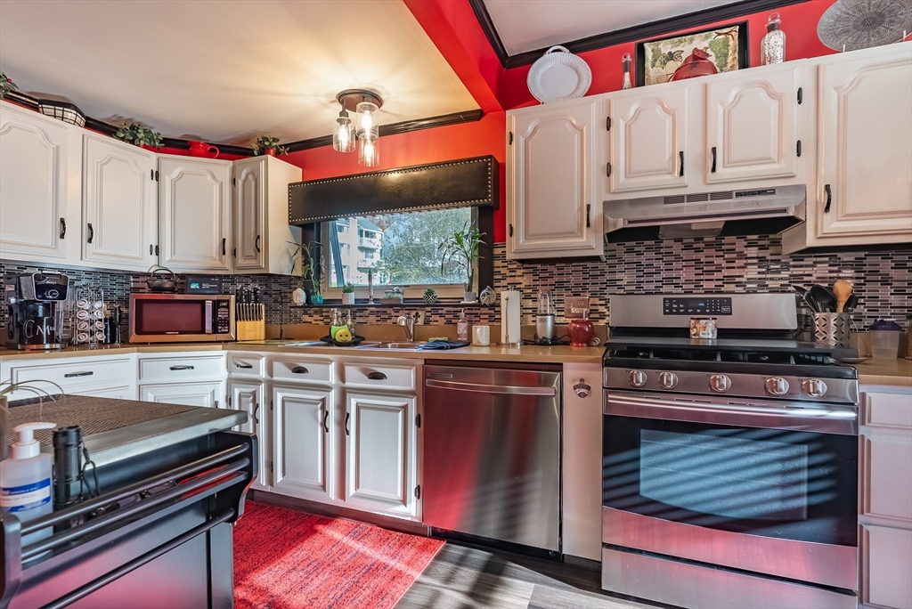 3853 North Main Street Fall River, MA 02720 - Photo 7 of 38 a kitchen with stainless steel appliances granite countertop a stove a sink and a microwave