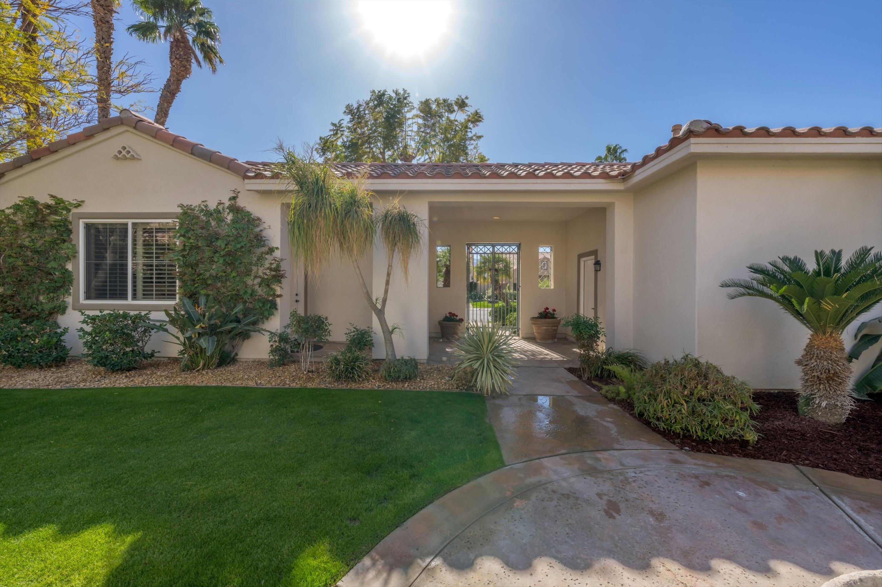 81100 Legends Way La Quinta, CA 92253 - Photo 15 of 37 a front view of a house with a garden and yard