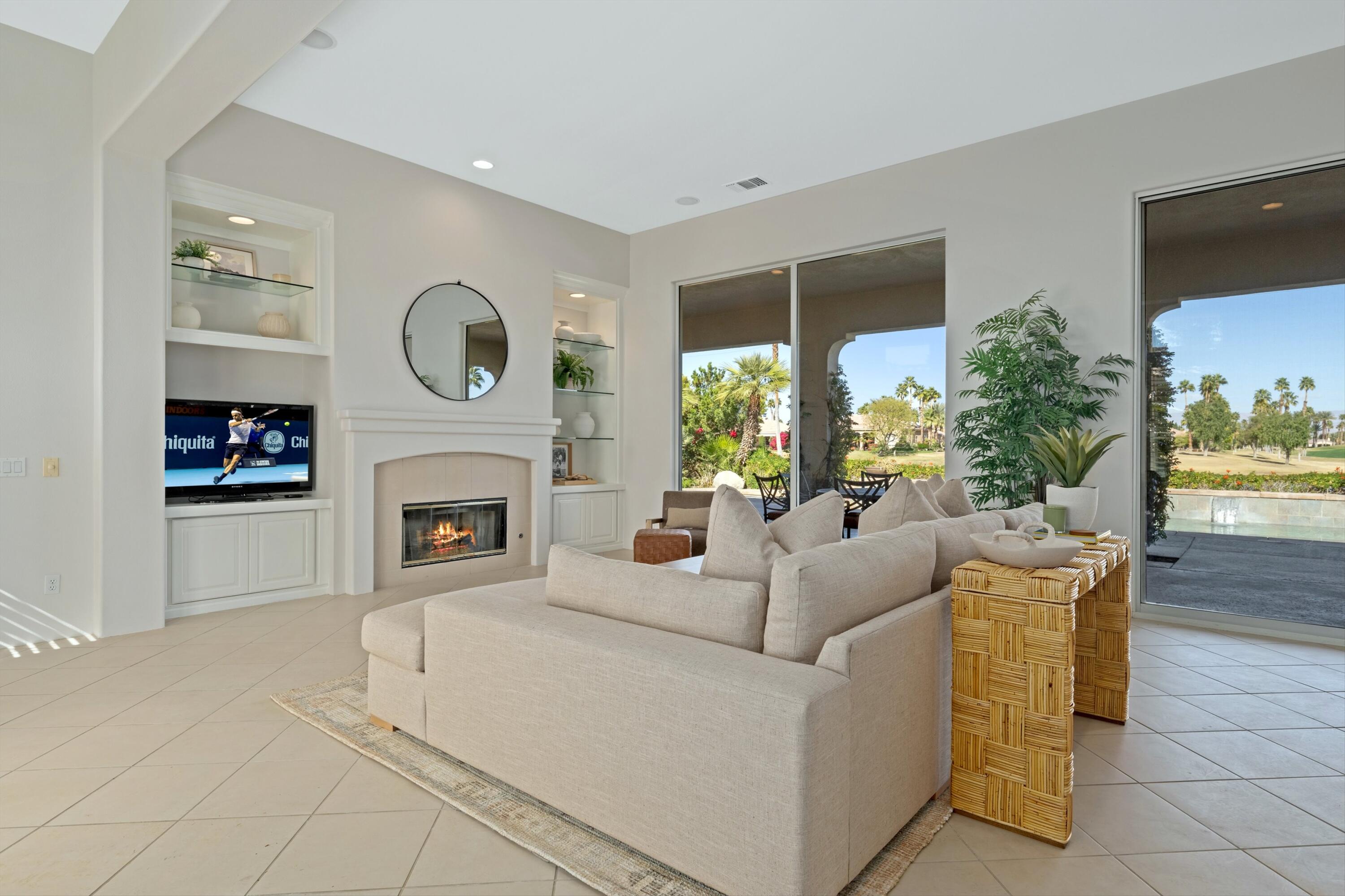 81100 Legends Way La Quinta, CA 92253 - Photo 17 of 37 a living room with furniture a fireplace and a large window