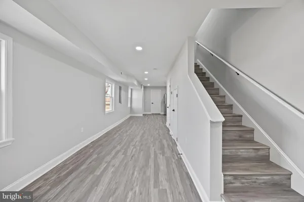 a view of a hallway with wooden floor and staircase