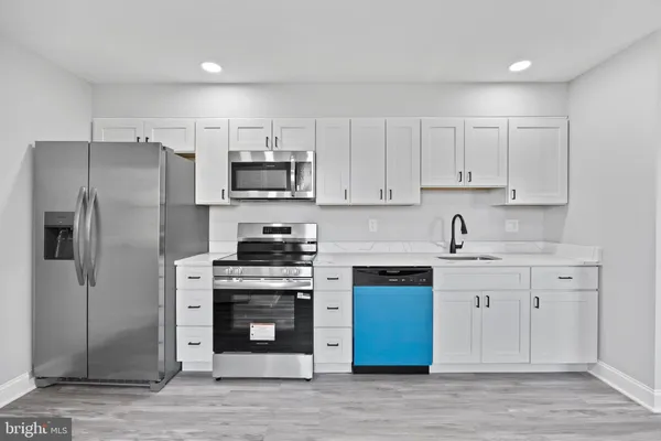 a kitchen with stainless steel appliances granite countertop a stove a refrigerator and a sink