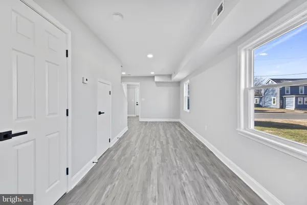 a view of a room with wooden floor closet and windows