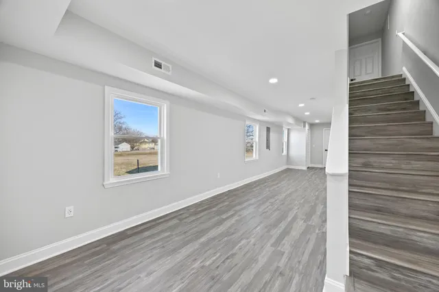 a view of a hallway with wooden floor and staircase