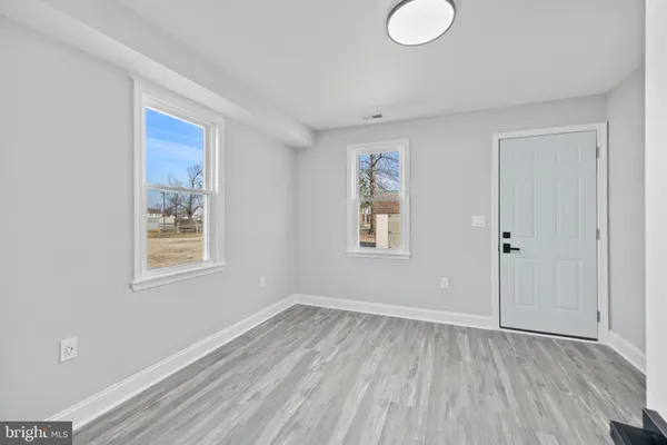 an empty room with a window and wooden floor