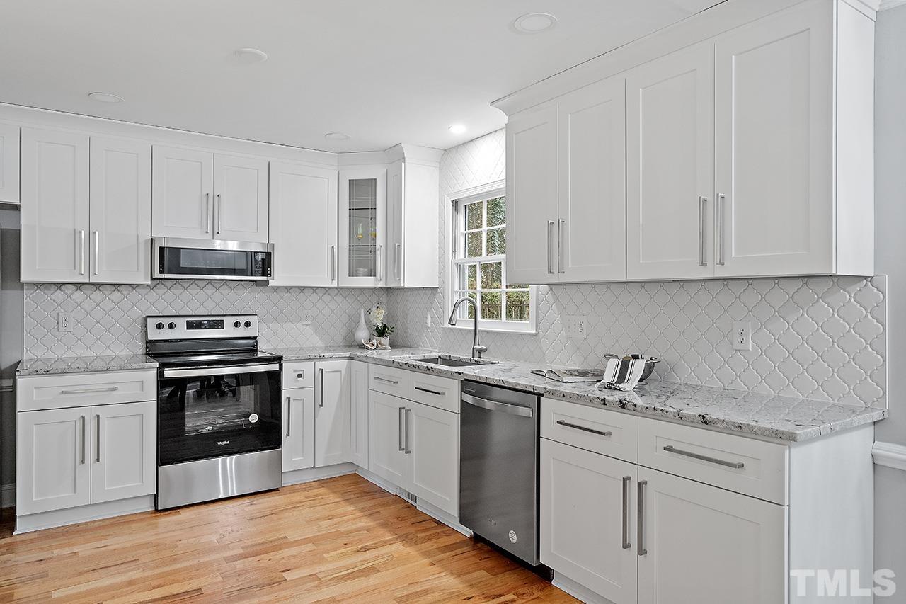 2800 Pidgeon Hill Road Raleigh, NC 27613 - Photo 3 of 35 a kitchen with stainless steel appliances granite countertop a stove a sink and white cabinets