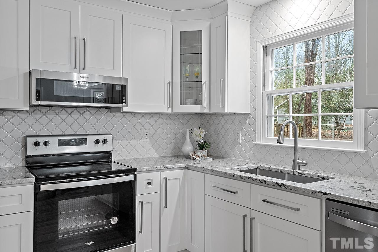 2800 Pidgeon Hill Road Raleigh, NC 27613 - Photo 8 of 35 a kitchen with granite countertop a stove a sink and a microwave