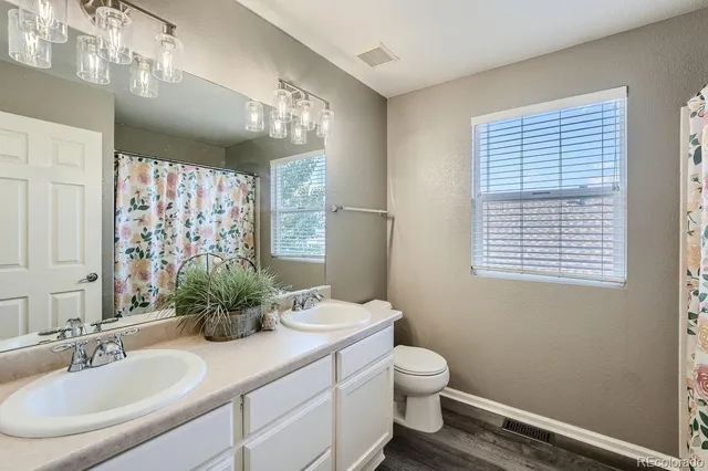 a bathroom with a granite countertop sink toilet and mirror