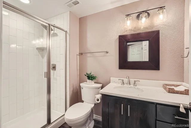 a bathroom with a sink vanity mirror and toilet