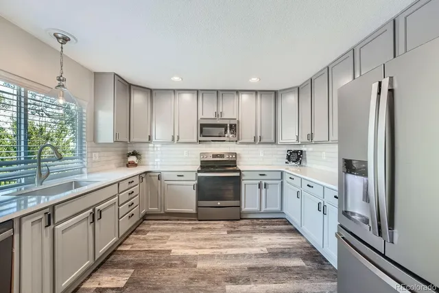 a kitchen with granite countertop white cabinets and white stainless steel appliances