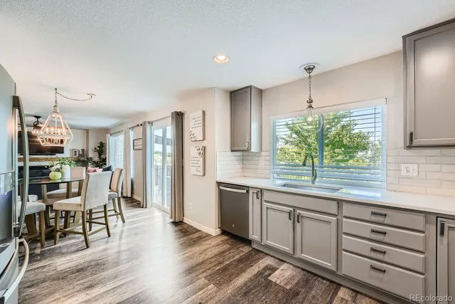 a kitchen with stainless steel appliances kitchen island granite countertop a table chairs and a large window
