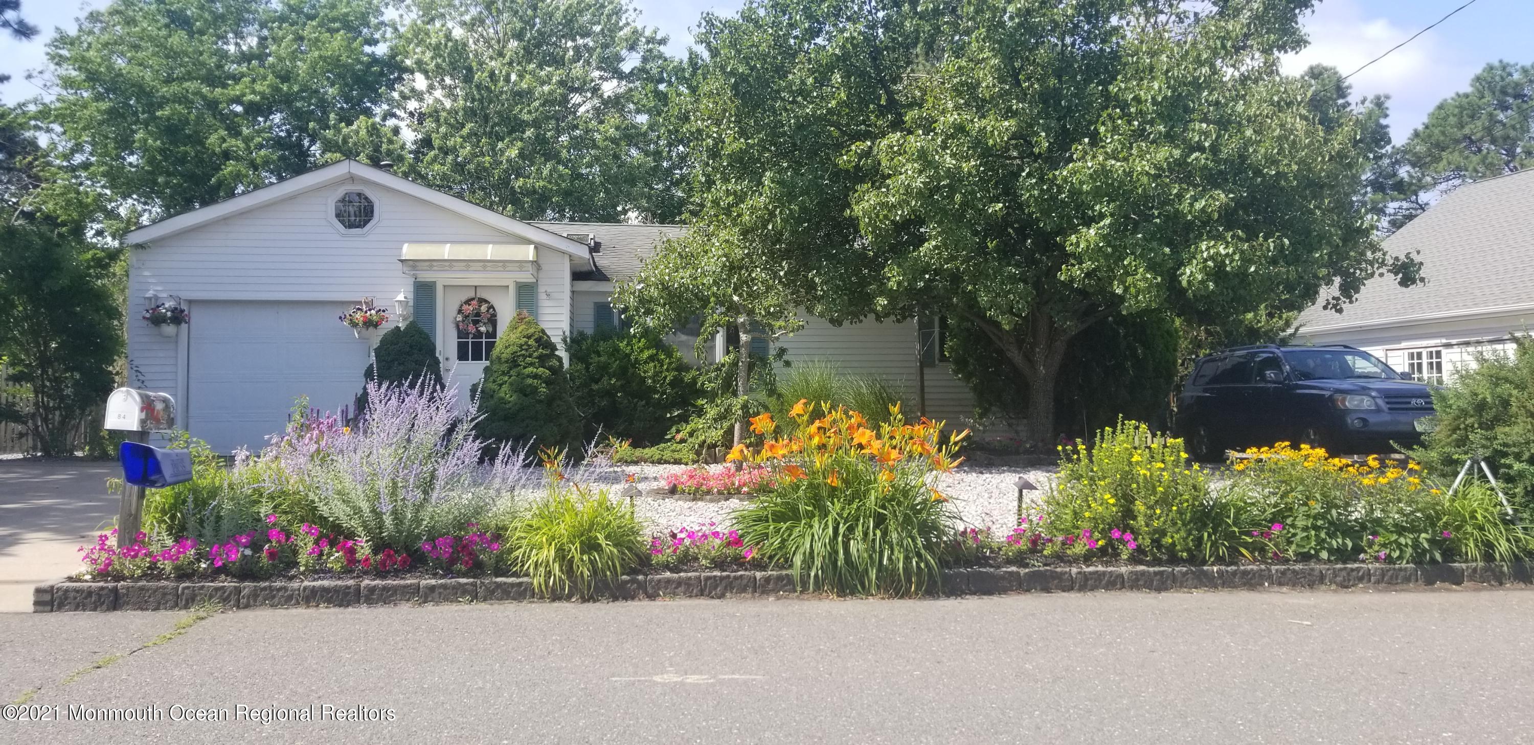 84 Club House Road Brick, NJ 08723 - Photo 1 of 28 a front view of a house with a yard and a garden