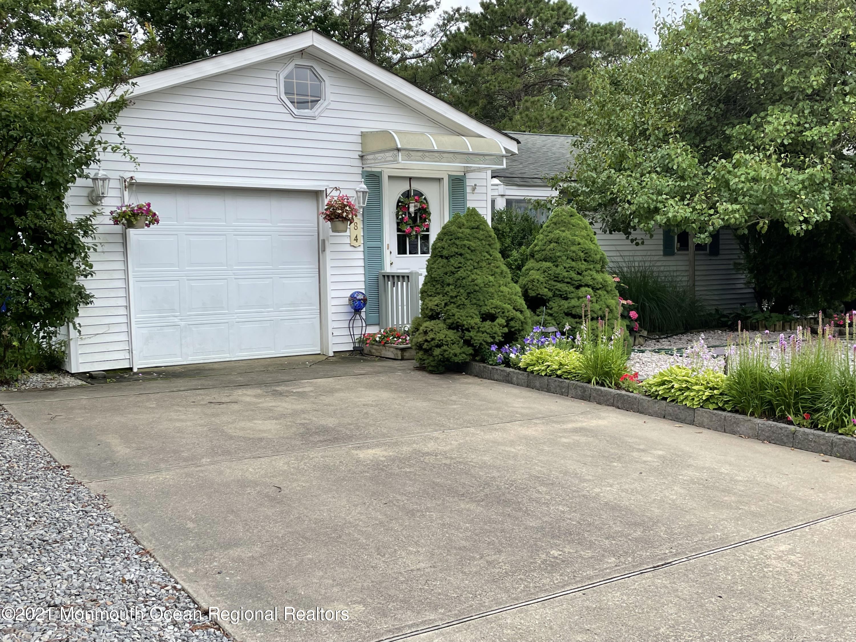 84 Club House Road Brick, NJ 08723 - Photo 2 of 28 a view of a white house with a small yard plants and large tree