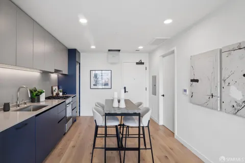 a kitchen with a dining table chairs and white cabinets