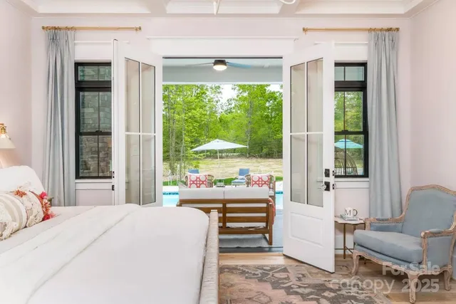 a bedroom with a bed and large windows