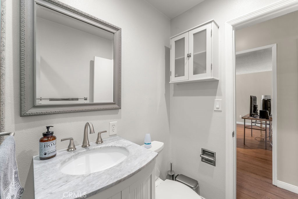 3540 Cannes Avenue Riverside, CA 92501 - Photo 13 of 32 a bathroom with a granite countertop toilet sink and mirror