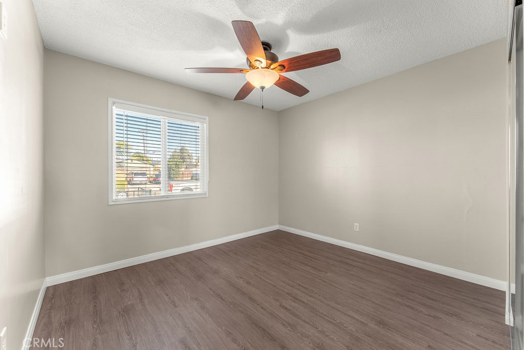3540 Cannes Avenue Riverside, CA 92501 - Photo 18 of 32 an empty room with wooden floor ceiling fan and windows