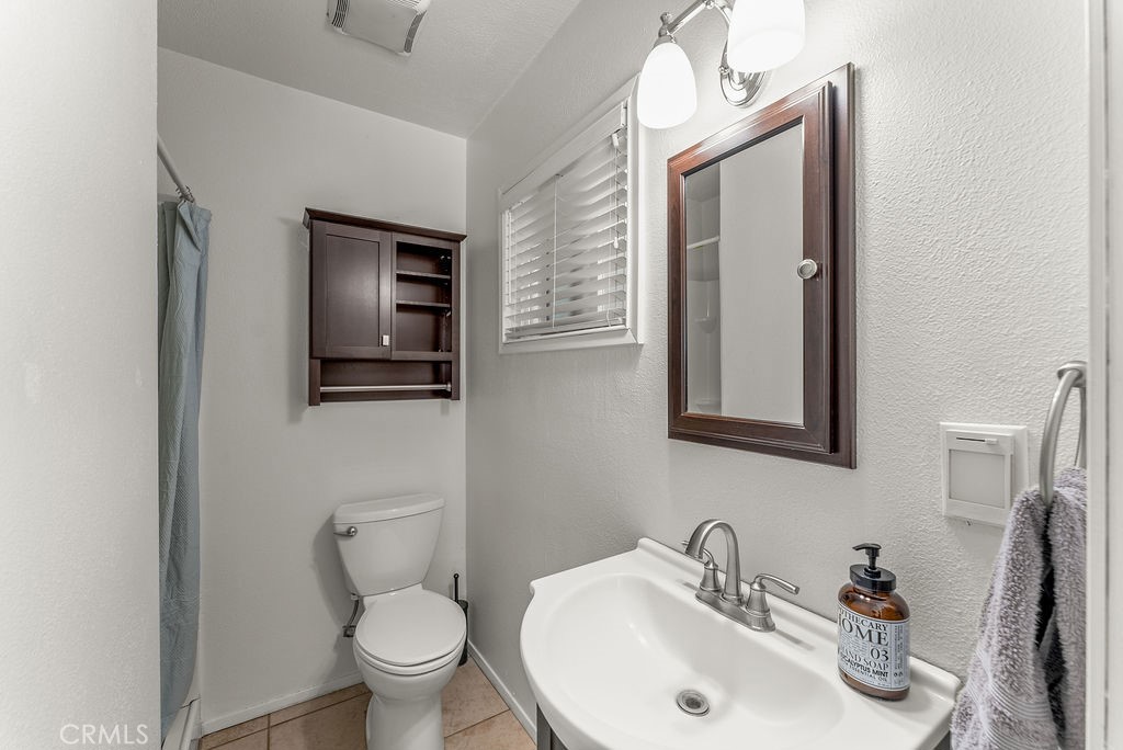 3540 Cannes Avenue Riverside, CA 92501 - Photo 23 of 32 a bathroom with a toilet sink and mirror