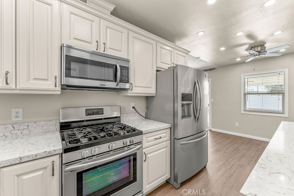 3540 Cannes Avenue Riverside, CA 92501 - Photo 9 of 32 a kitchen with stainless steel appliances granite countertop a stove microwave and refrigerator
