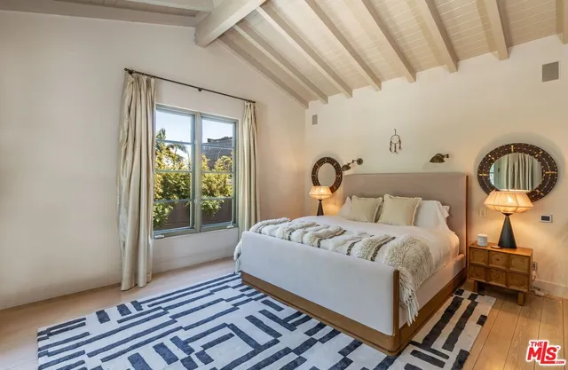 a bedroom with a bed wooden floor and window