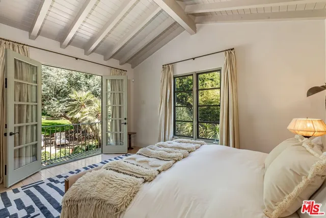 a bedroom with a bed and a large window with outer view