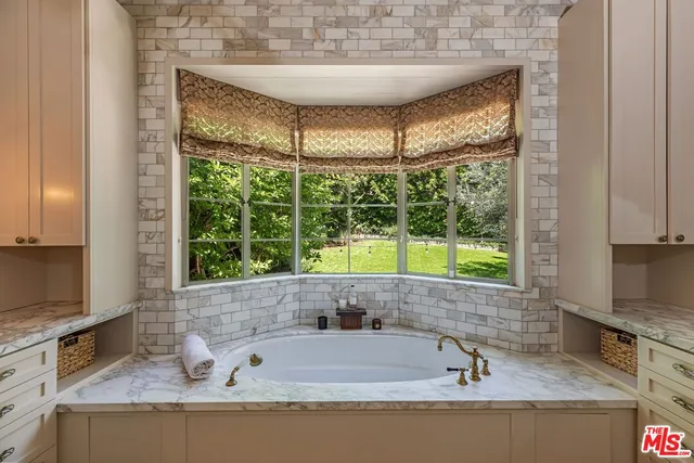 a bathroom with a granite countertop tub and a sink