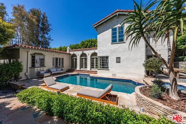 a view of a house with swimming pool and sitting area