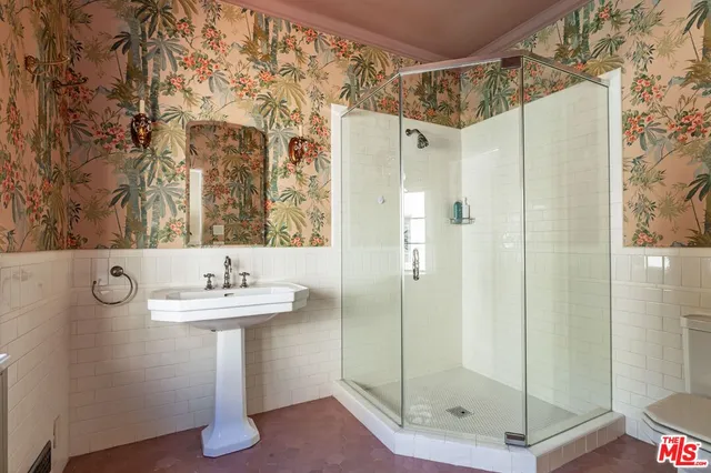 a bathroom with a shower a mirror and a sink