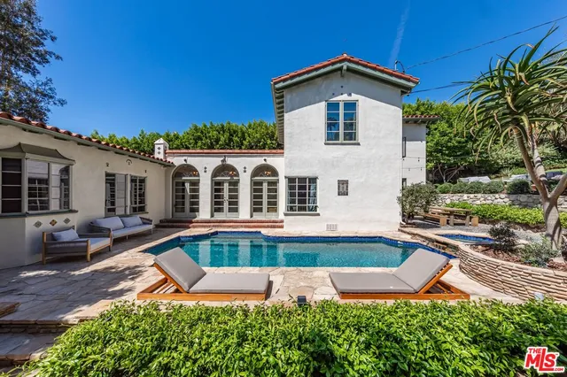 a front view of a house with swimming pool having outdoor seating