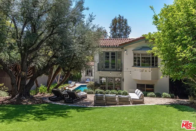 a front view of a house with garden and chairs