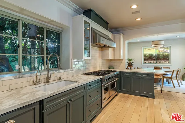 a kitchen with stainless steel appliances granite countertop a sink stove and cabinets