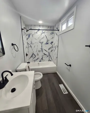 a bathroom with a sink a toilet and shower