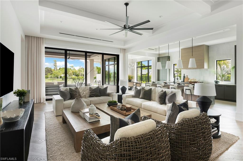 6704 Newport Road Naples, FL 34109 - Photo 7 of 47 a living room with furniture a large window and a flat screen tv