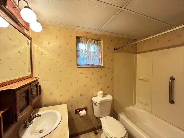 a white toilet sitting next to a bathroom sink and a shower
