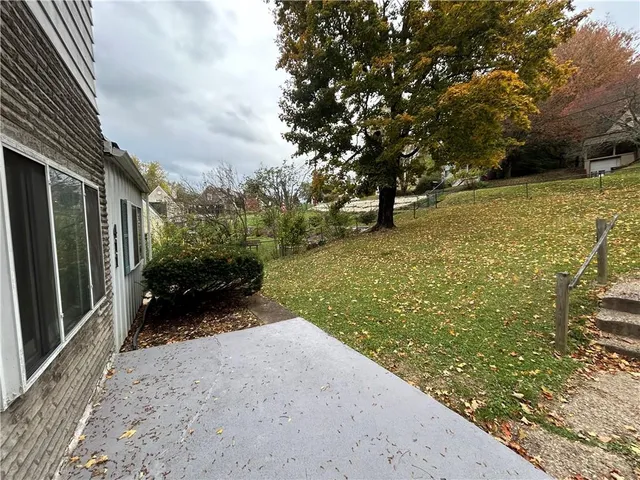 a view of a yard with an tree and wooden fence