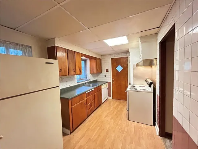 a kitchen with refrigerator and white cabinets