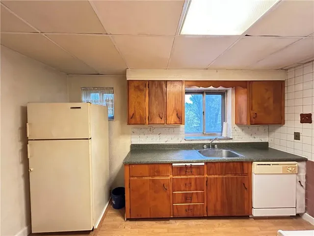 a kitchen with stainless steel appliances granite countertop a refrigerator a sink a stove a microwave and cabinets