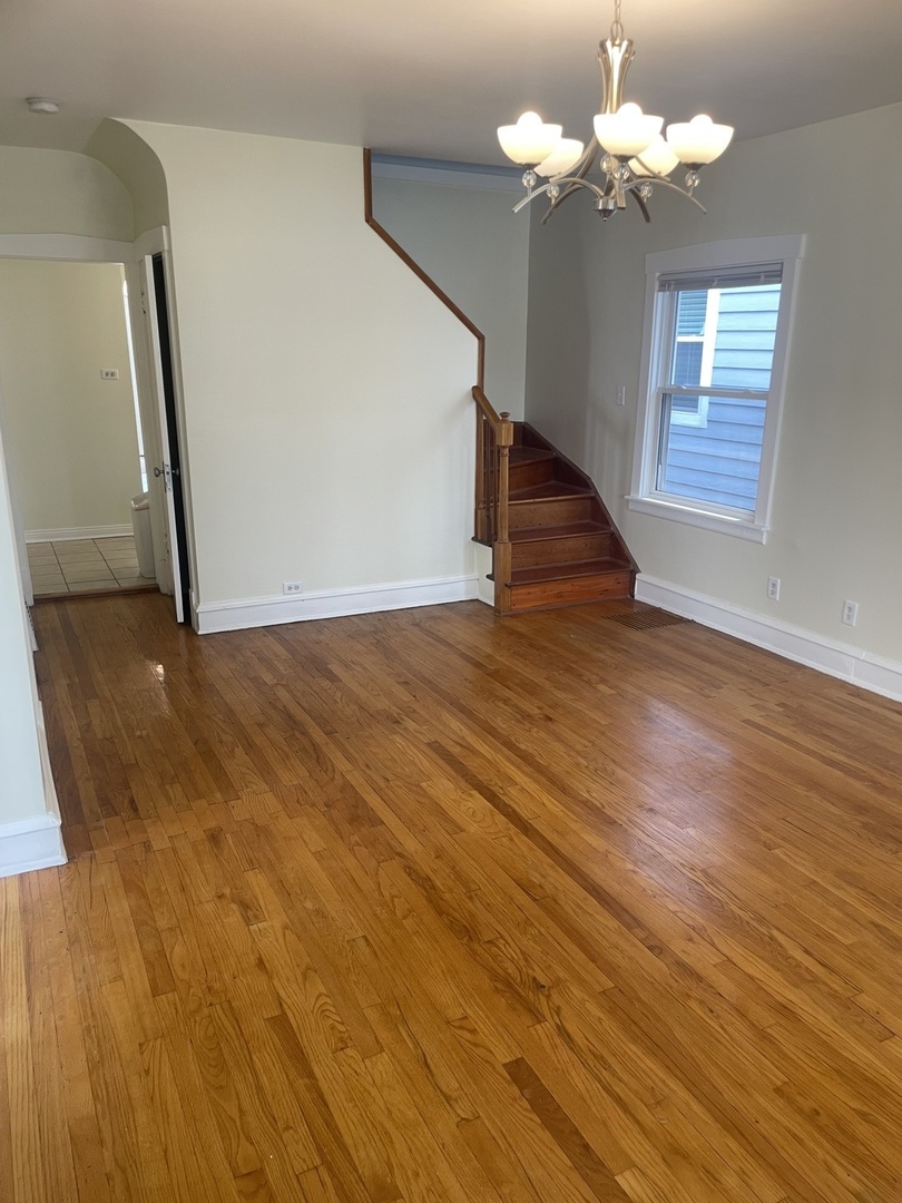 Undisclosed Address Forest Park, IL 60130 - Photo 4 of 16 a view of an empty room with wooden floor and fan